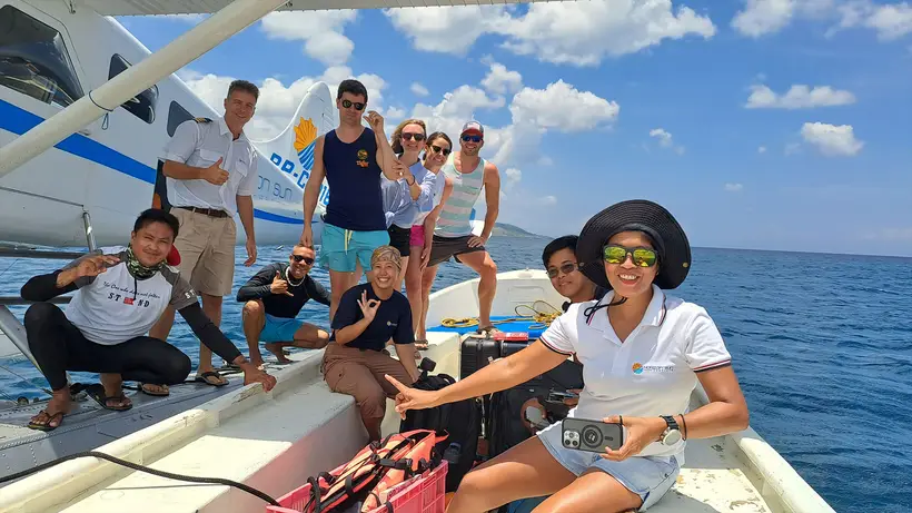 Smiling guests and crew on a boat on the way to the seaplane