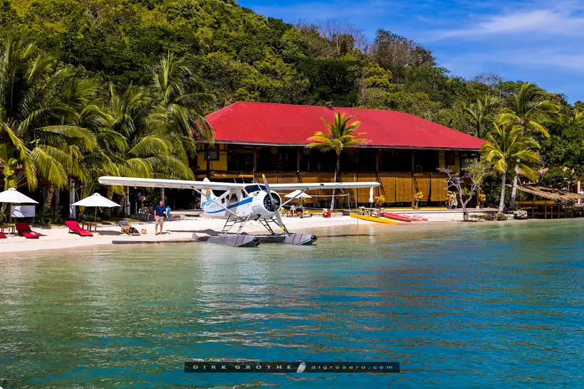 The Horizon Sun Beaver moored at a resort beach with a red-roofed clubhouse